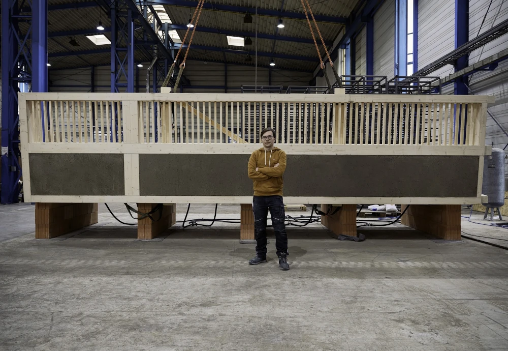 Julian Trummer vor der fertigen Lehm-Holz-Massivdecke stehend.