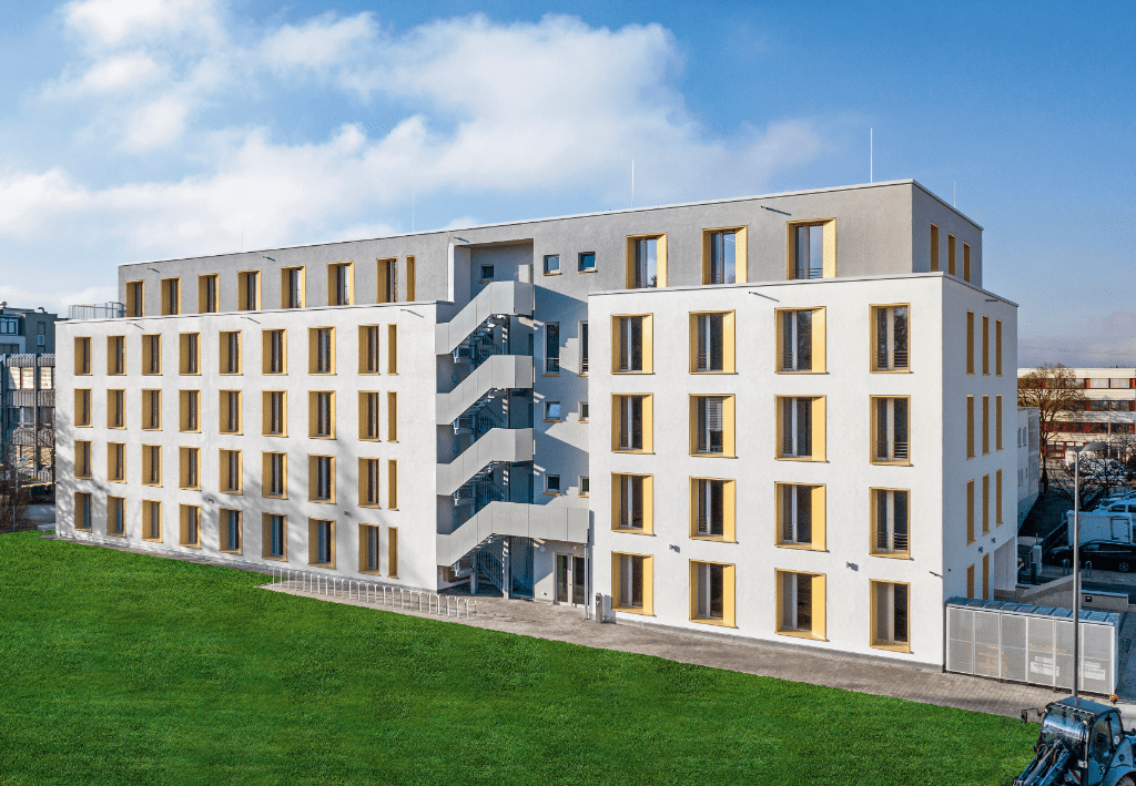 Gebäude aus Coriso-Ziegel mit fertiger Fassade, das vor einem grünen Rasen gebaut wurde.