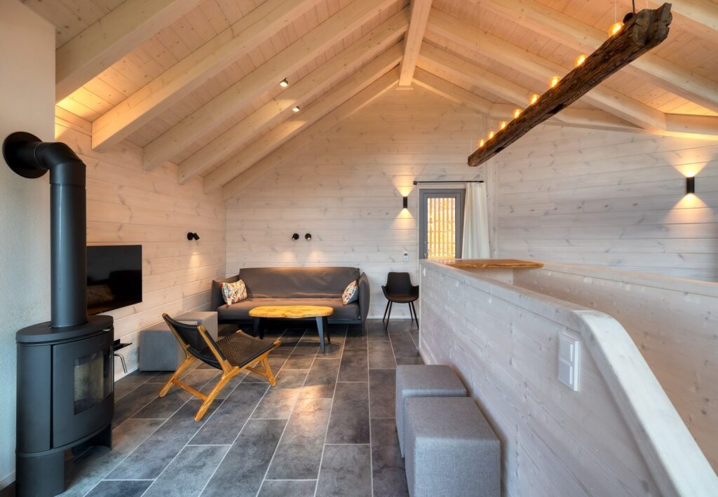 Wohnzimmer im Schwarzwald-Ferienhaus, ausgestattet mit einem Holzofen und einer bequemen Couch für entspannte Stunden.