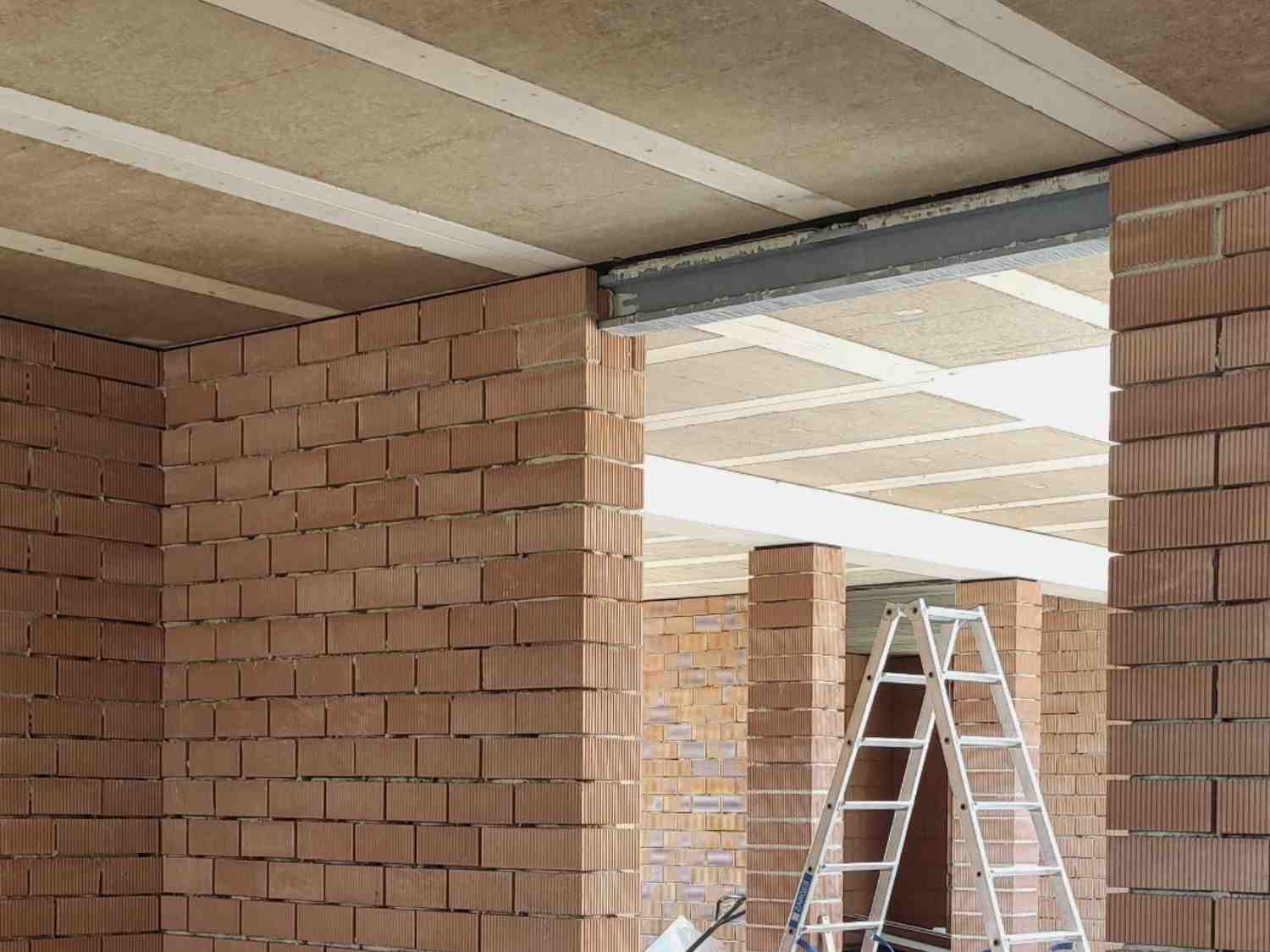 Ein Raum mit Ziegelwänden und einer Leiter, die an der Wand lehnt.